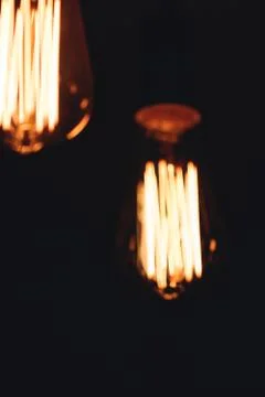 Blurred image of glowing retro light bulbs at night. Stock Photos