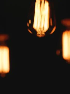 Blurred image of glowing retro light bulbs at night. Stock-Fotos