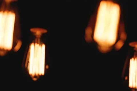 Blurred image of glowing retro light bulbs at night. Fotos Stock