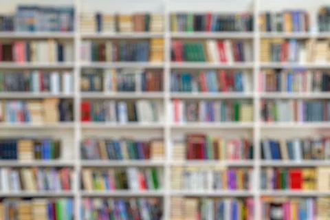 Blurred image of a library with bookcases. Many different books on the shelve Stock Photos