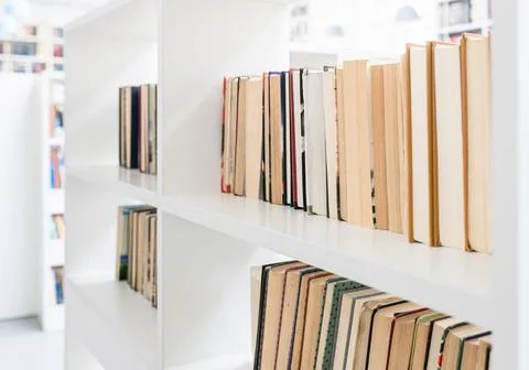 Blurred image of a library with bookcases. Many different books on the shelve Stock Photos