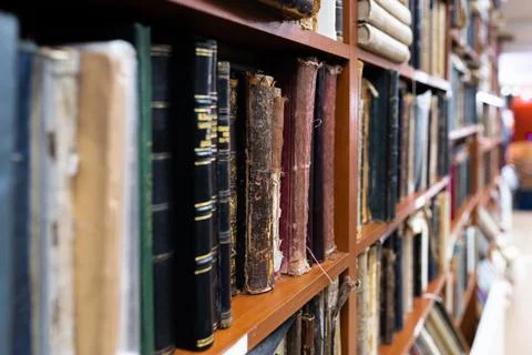 Blurred image of a library with bookcases. Many different books on the shelves Stock Photos
