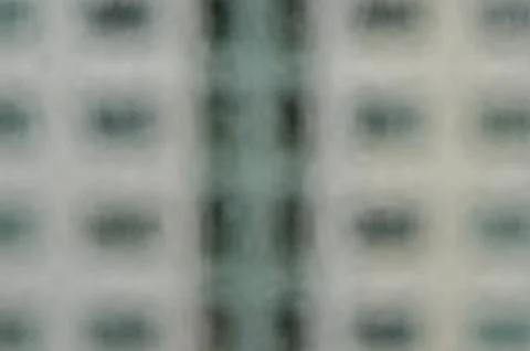 Blurred image, rain drops on window against building background. Stock Photos