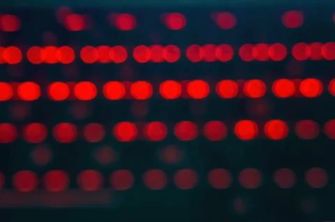Blurred image of red LED lights in rows, creating a bokeh effect. Perfect f.. Stock Photos