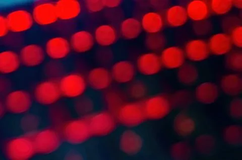 Blurred image of red LED lights in rows, creating a bokeh effect. Perfect f.. Stock Photos