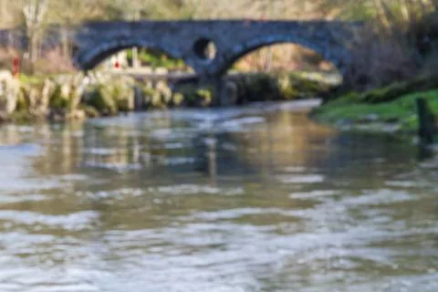 Blurred image of river and stone bridge Stock Photos