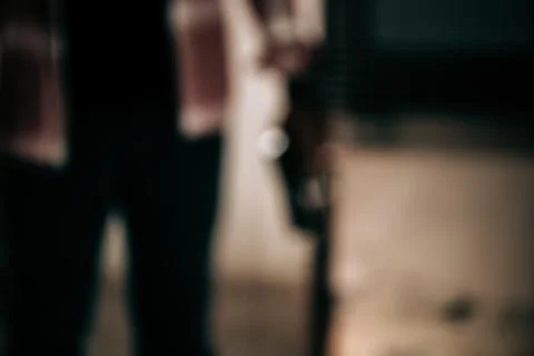 Blurred image of a robber concept wearing a striped shirt with a gun breaking Stock Photos
