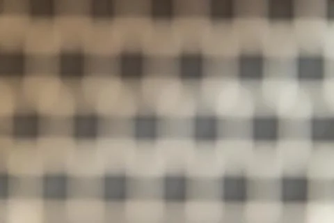 A blurred image showcasing a checkered pattern with subtle bokeh effects. The Stock Photos