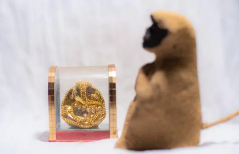 Blurred image of a toy monkey sitting before an idol of Hindu god in white co Stock Photos
