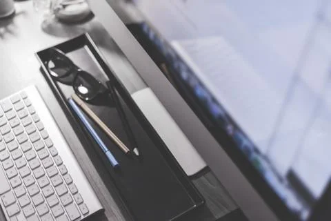 Blurred large computer screen on a home office desk interior eith work object Stock Photos