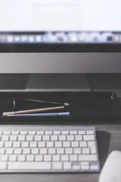 Blurred large computer screen on a home office desk interior eith work object Stock Photos