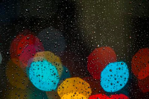 Blurred light with rain drops on the window Stock Photos