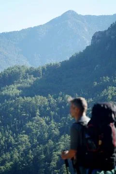 Blurred man with a backpack against the background of a mountain Stock Photos