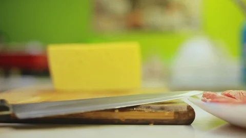 Blurred man hands slices cheese with knife on wooden board Video stock 95910161