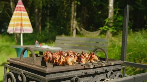 Blurred man sitting at wooden table in backyard and drinking beer while mea.. Stock Footage 339134868