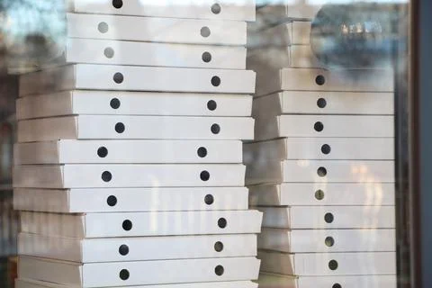 Blurred many white boxes in the window of a pizza delivery service. Soft focus. Stock Photos