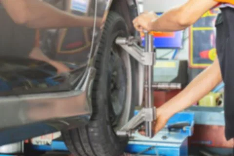 Blurred of Mechanic fixing the wheel alignment device onto a car wheel Photos