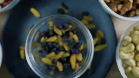 Blurred Mixed Nuts and Dried Fruits in Bowls Stock Footage 320727572