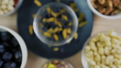 Blurred Mixed Nuts and Dried Fruits in Bowls Stock Footage 320727592