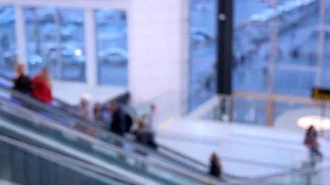 Blurred modern office interior with an escalator, spacious windows, and abundant Stock Footage 277562532