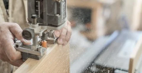 Blurred motion of carpenter working, preparing door for hinges Stock Photos
