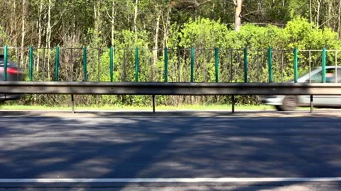 Blurred motion side view of fast moving cars on the road in a sunny day Stock Footage 220827608