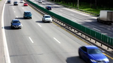 Blurred motion view of fast moving cars on the road in a sunny day Stock Footage 220827565