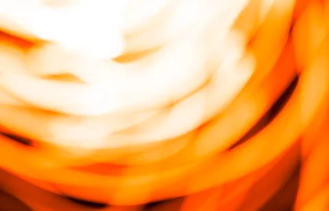 Blurred moving fire lights background, yellow, orange and white colors on bla Stock Photos