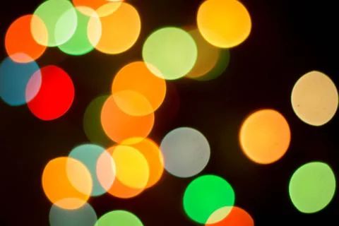 Blurred multicolored lights on a dark background. Stock Photos
