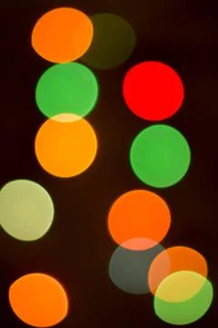 Blurred multicolored lights on a dark background. Stock Photos