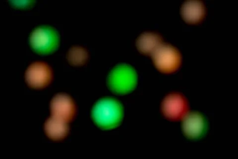 Blurred multicolored lights on a dark background. Stock Photos