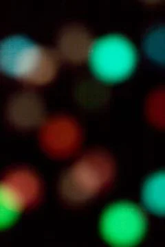 Blurred multicolored lights on a dark background. Stock Photos