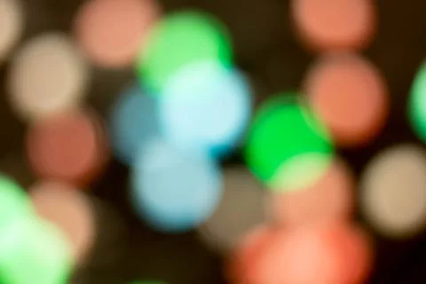 Blurred multicolored lights on a dark background. Stock Photos