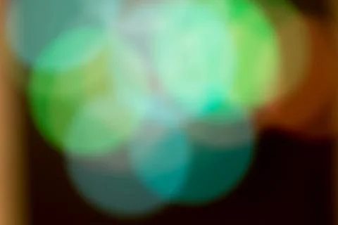Blurred multicolored lights on a dark background. Stock Photos