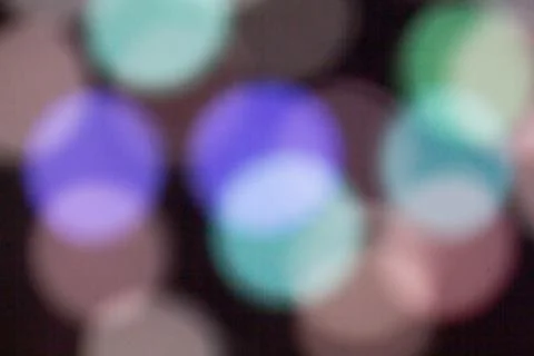 Blurred multicolored lights on a dark background. Stock Photos