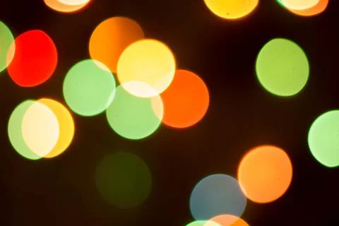Blurred multicolored lights on a dark background. Stock Photos