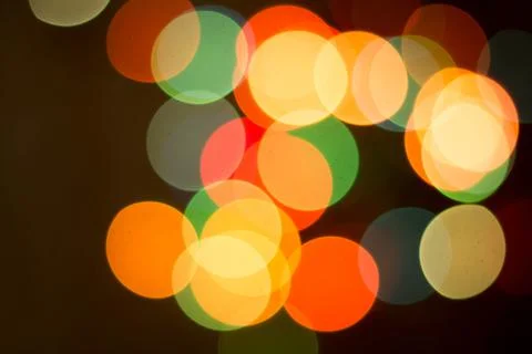 Blurred multicolored lights on a dark background. Stock Photos