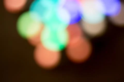 Blurred multicolored lights on a dark background. Stock Photos