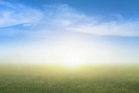 Blurred nature background image of blur green grass and blue sky background.. Stock Photos