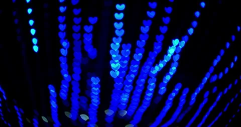 Blurred neon lights in the shape of a heart run in the dark Stock Footage 255877384