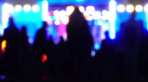 Blurred people going to night show. Bright stage lighting. 4K background bokeh Stock Footage