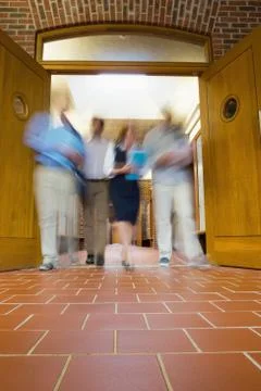 Blurred people walking through open doors Foto stock