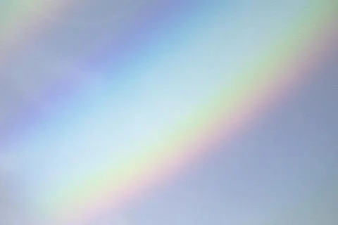 Blurred rainbow light refraction texture on white wall Stock Photos