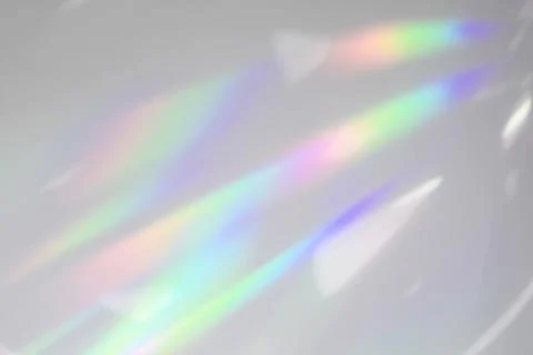 Blurred rainbow light refraction texture on white wall Stock Photos