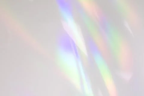 Blurred rainbow light refraction texture on white wall Stock Photos
