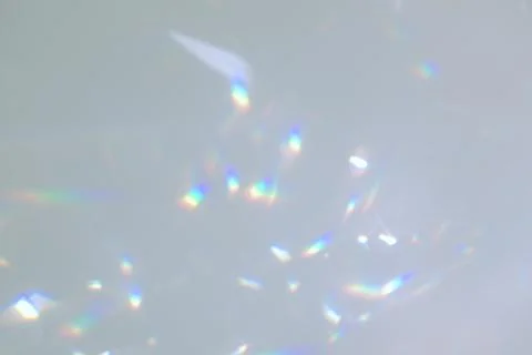 Blurred rainbow light refraction texture on white wall Stock Photos