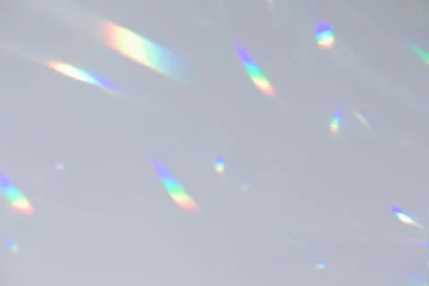 Blurred rainbow light refraction texture on white wall Stock Photos