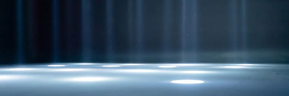 Blurred rays of light on the disco floor. white blue neon searchlight lights. Stock Photos