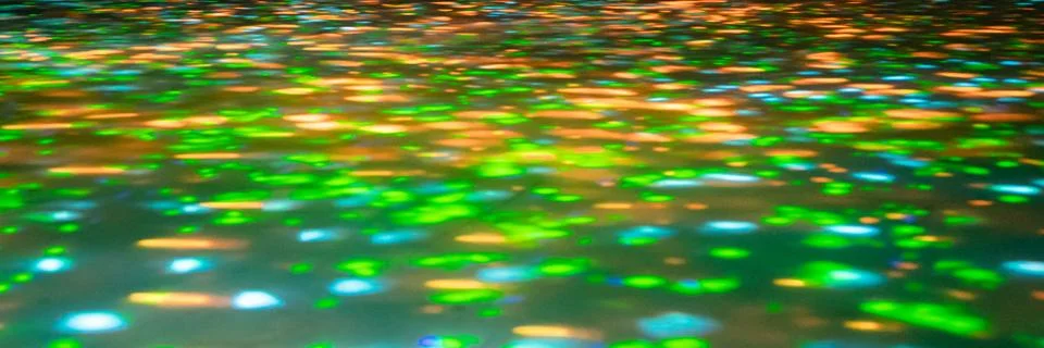 Blurred rays of light on the disco floor. red green blue neon searchlight lig Stock Photos