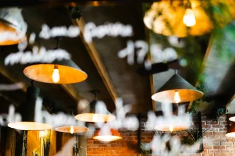 Blurred reflection of the ceiling of a cafe with beautiful lamps. Out of focus Foto stock